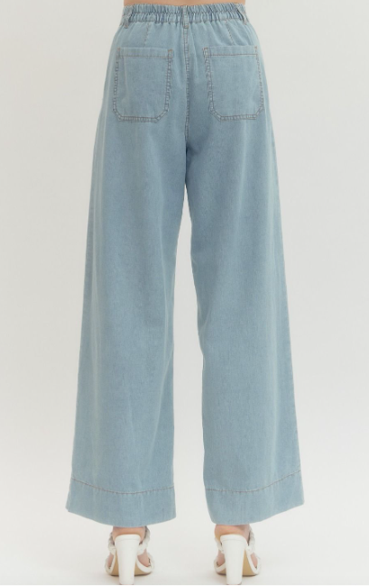Denim wide leg pants featuring front patch pockets and stitched waistband