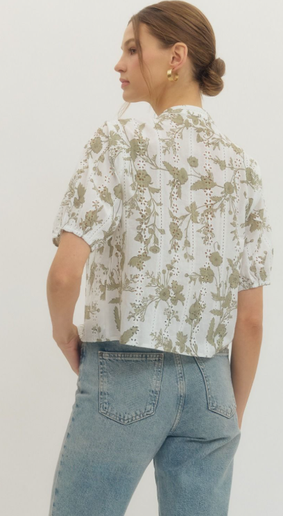 Floral eyelet puff sleeve top featuring V-neck yoke and front button closure.