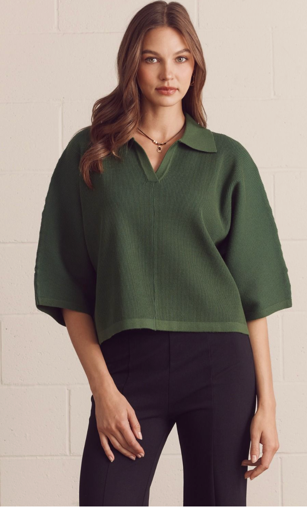 Solid 3/4 sleeve knit top featuring open V-neck collar. Unlined. Knit. Non-sheer. Medium weight.