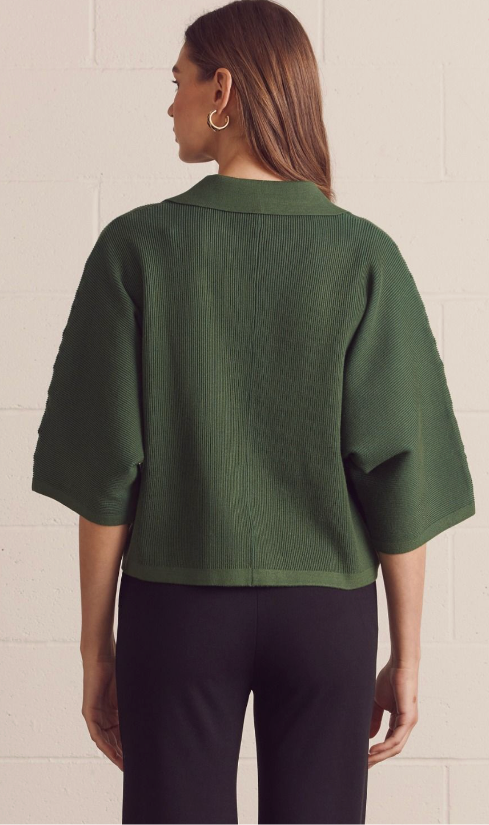 Solid 3/4 sleeve knit top featuring open V-neck collar. Unlined. Knit. Non-sheer. Medium weight.