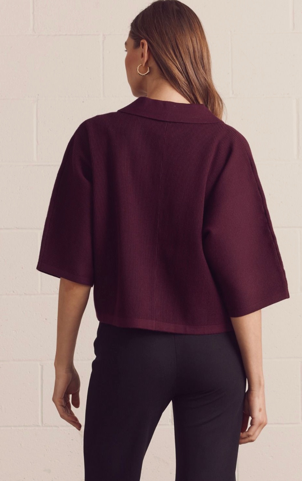 Solid 3/4 sleeve knit top featuring open V-neck collar. Unlined. Knit. Non-sheer. Medium weight.