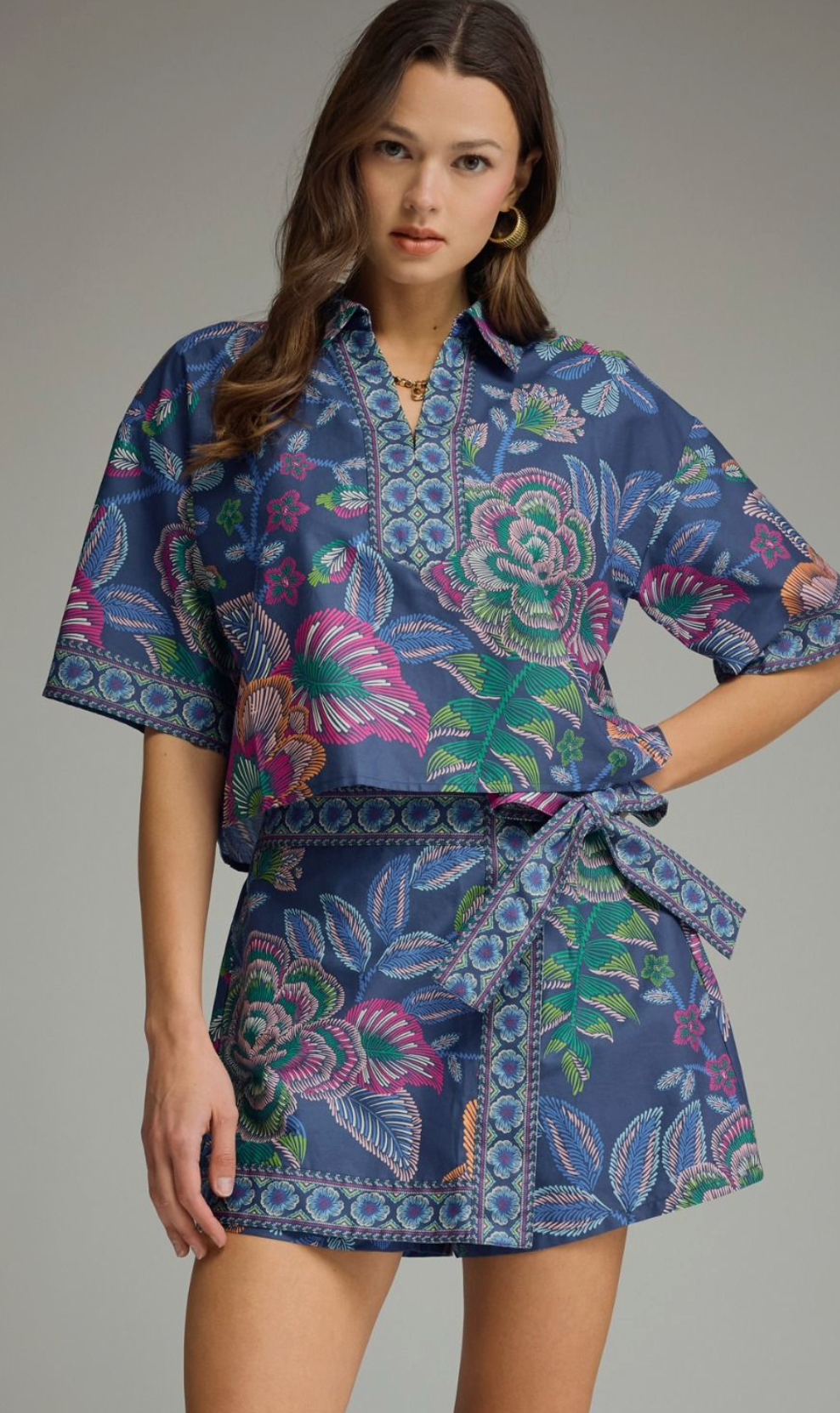 Botanical print short sleeve top featuring split V-neck collar. Back center pleat detail. Unlined. Woven. Non-sheer. Lightweight.