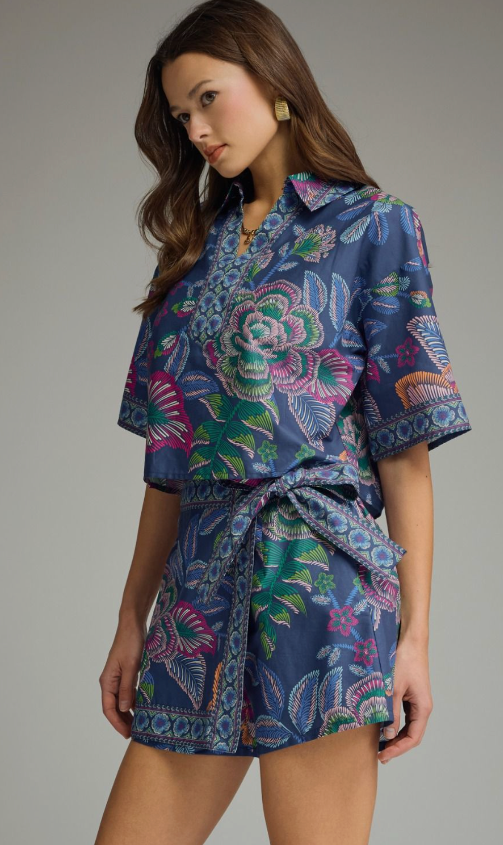 Botanical print short sleeve top featuring split V-neck collar. Back center pleat detail. Unlined. Woven. Non-sheer. Lightweight.