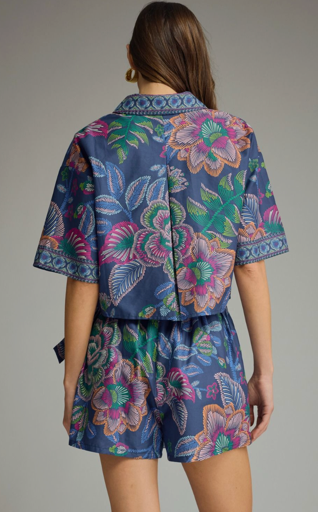 Botanical print short sleeve top featuring split V-neck collar. Back center pleat detail. Unlined. Woven. Non-sheer. Lightweight.