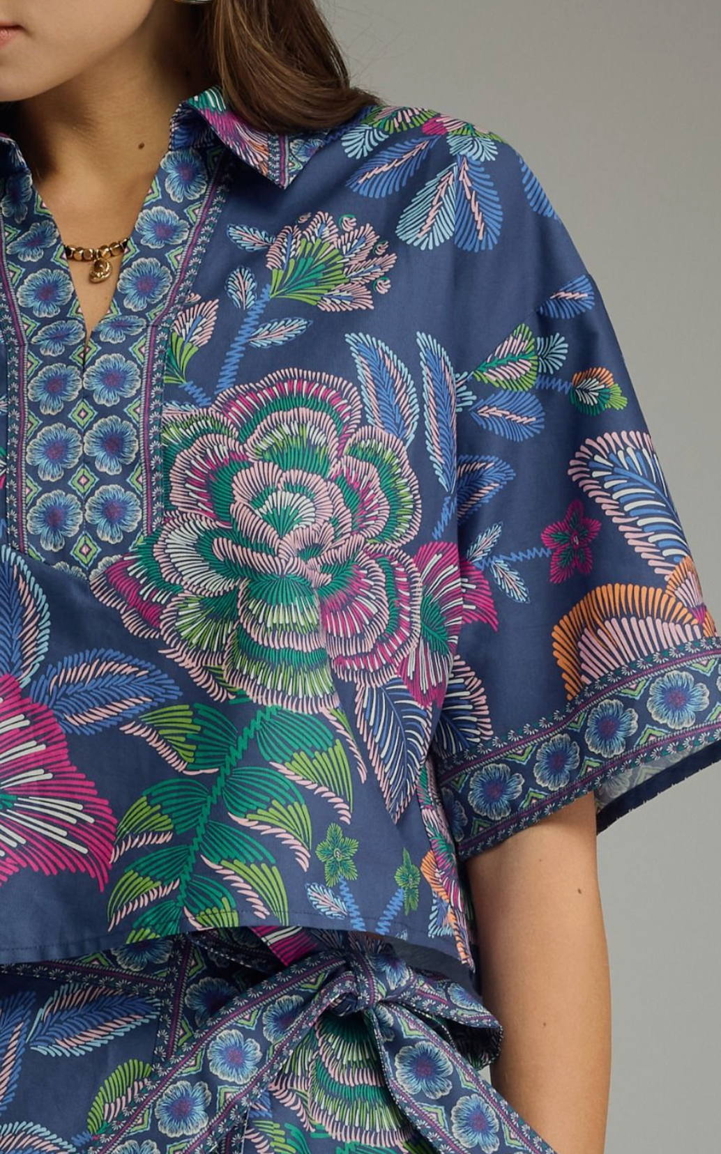Botanical print short sleeve top featuring split V-neck collar. Back center pleat detail. Unlined. Woven. Non-sheer. Lightweight.