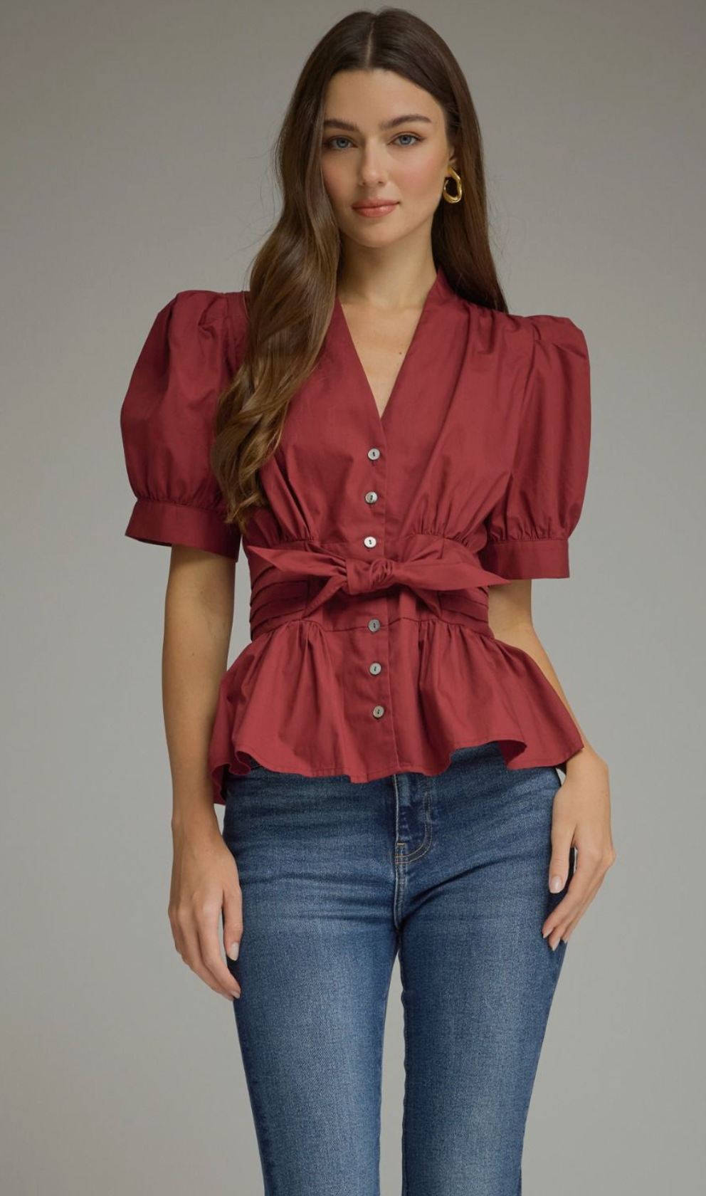 Solid short puff sleeve top featuring a V-neck, self-tie waist, and ruffle hem. Button closure at front. Smocked detail at back waist. Unlined. Woven. Non-sheer. Lightweight.