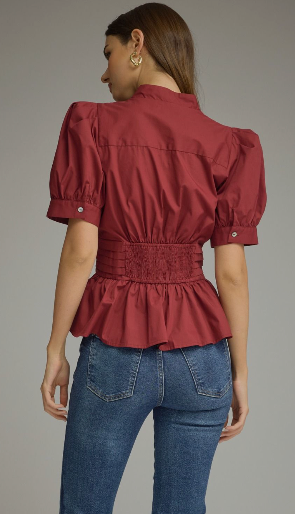 Solid short puff sleeve top featuring a V-neck, self-tie waist, and ruffle hem. Button closure at front. Smocked detail at back waist. Unlined. Woven. Non-sheer. Lightweight.