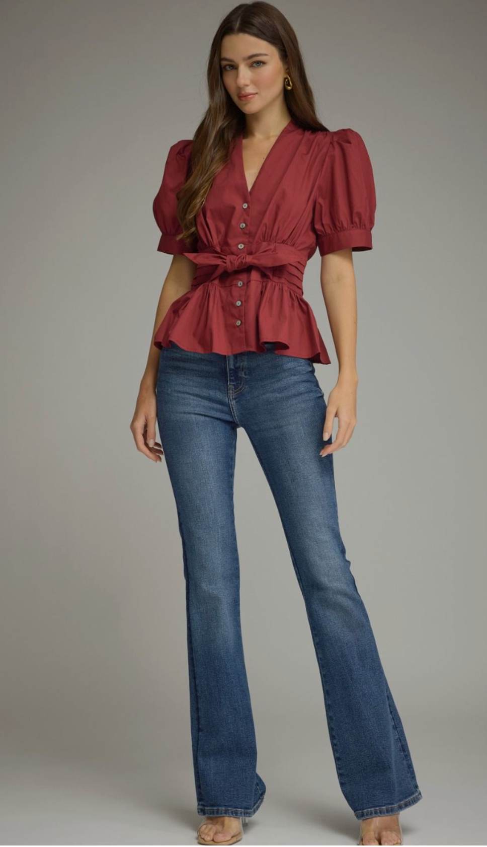 Solid short puff sleeve top featuring a V-neck, self-tie waist, and ruffle hem. Button closure at front. Smocked detail at back waist. Unlined. Woven. Non-sheer. Lightweight.