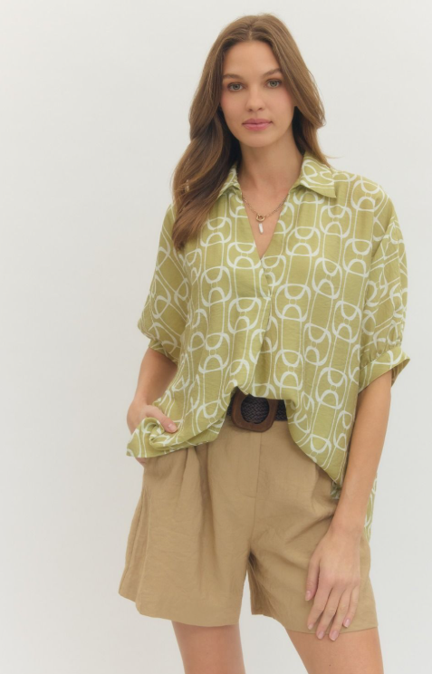 MATCHA. Geometric print short sleeve top featuring open stand collar and front button closure.